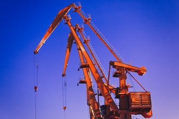 Mobile harbor cranes over blue sky. Transport and technology concept