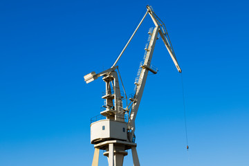 Mobile harbor cranes over blue sky. Transport and technology concept
