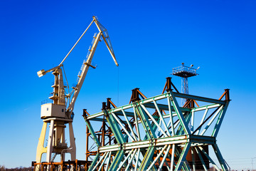 Mobile harbor cranes over blue sky. Transport and technology concept
