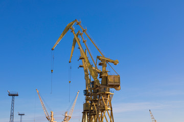 Mobile harbor cranes over blue sky. Transport and technology concept