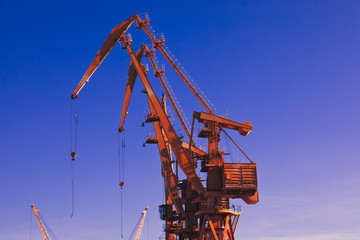 Mobile harbor cranes over blue sky. Transport and technology concept
