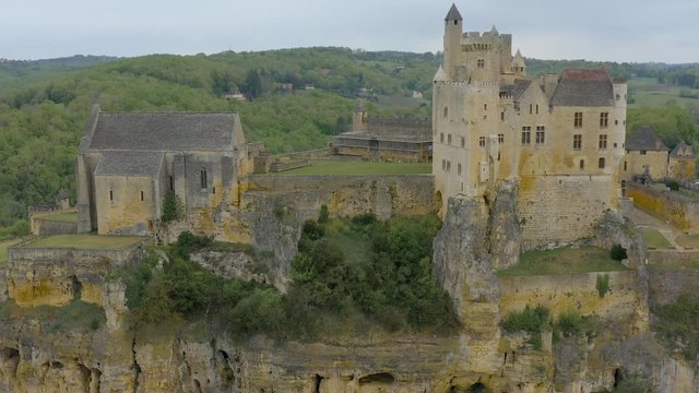 Aerial view Castle of Beynac build in a cliff over Dordogne River. Yellow, white and ocre colors dominates the rocks. Aquitaine, Southern France.