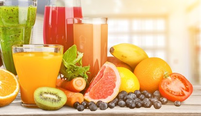 Fresh ripe healthy fruits and juices in glasses
