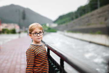 Obraz premium Strong, smart and funny little boy playing outdoors, wearing eyeglasses. Problem with eyes, astigmatism