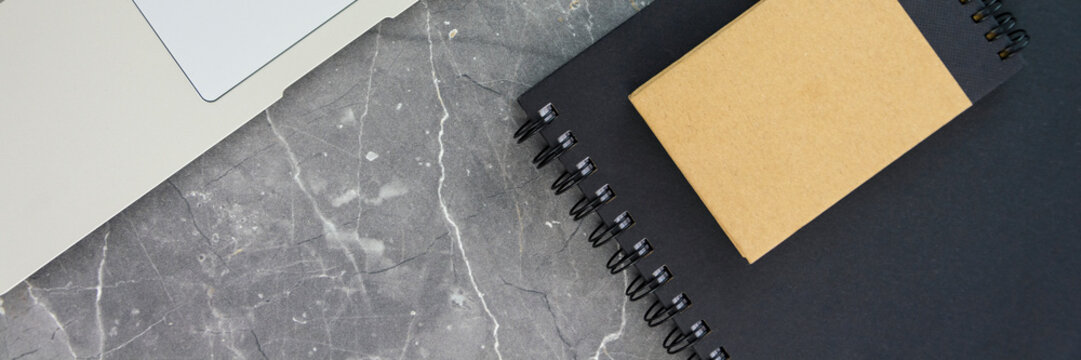 laptop computer and notebooks on concrete table panorama