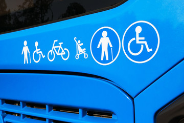  icons on blue city bus side - disabled, senior, baby and bicycle signs on modern accessible urban...