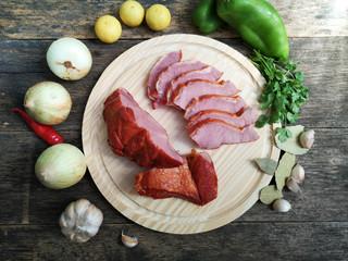Rustic wooden board with smoked meat on wooden board