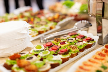 Close up of various canapes served in plate on buffet table.