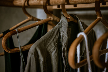 Boho chic open wardrobe, clothing rack, rappan wooden hangers, Fashion blogging concept, neutral colors. Loft bedroom interior design