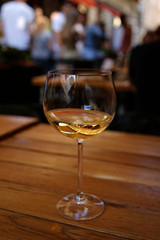 closeup of white wine glass at the table of street cafe