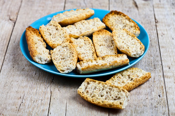 Naklejka premium Fresh italian croutons crostini on blue plate.
