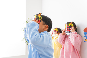 節分のお面をかぶる子どもたち