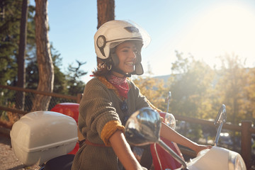 Cheerful woman riding a scooter and looking at Italy on vacation. © luckybusiness