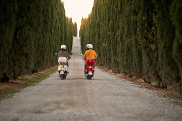 Romantic man and woman riding on a scooter in European on vacation. Back view.. © luckybusiness