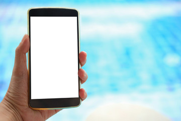 hand holding smart phone near swimming pool