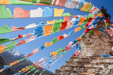 Colorful tibetan flags and snow mountain at Siguniang scenic area in autumn season,chengdu, China.