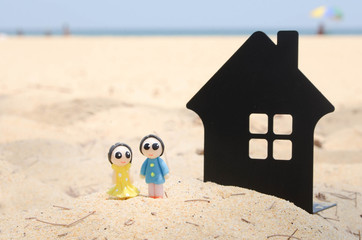 miniature couple and miniature house on the beautiful tropical beach.