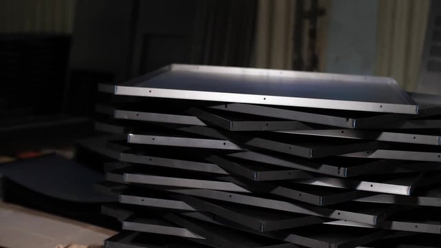  Close up many metal sheets lie on each other. Finished products industrial plant. Cut metal sheets are on the processing table. Manufacturing of metal parts for industry. 