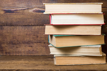 old books stacked on a wooden shelf