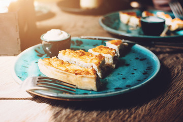 Chicken Quiche with mushrooms Recipe. Quiche Lorraine with chicken and Champignons and sauce on a blue plate on wooden table. Pie with chicken and mushrooms
