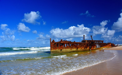 The rusty wreck of the vessel Maheno on the shores of Fraser Island (Queensland, Australia). The antique rusty and damaged boat and corrosion in the ocean sea.