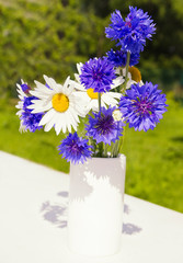 bouquet of flowers in glass vase on white background