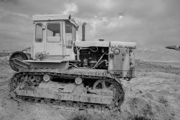Fototapeta na wymiar Black and white photo of old, rusty, tracked, Diesel, Caterpillar tractor.