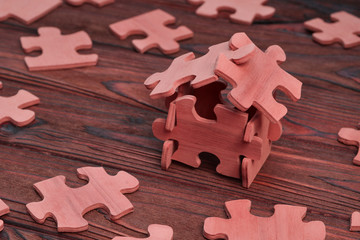 house of wooden puzzles on a wooden background.  real estate, business, financial planning.
