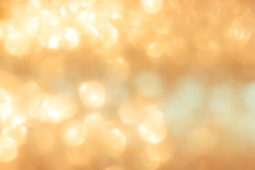 Blur yellow gold bokeh background of reflective glittering light from holiday party crystal ball...