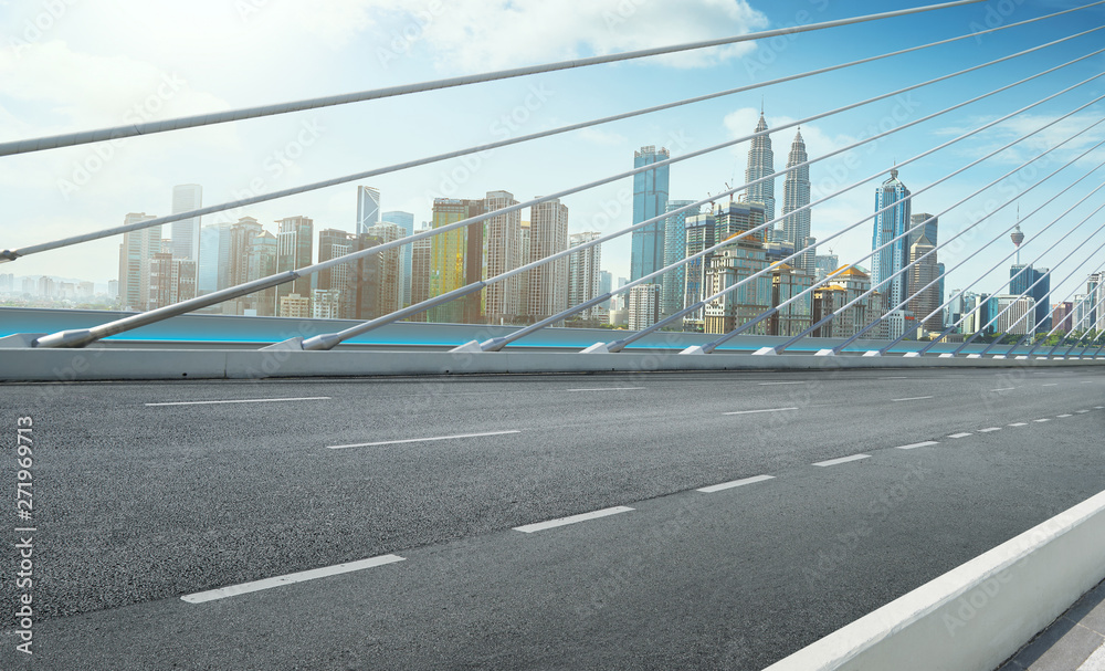 Wall mural modern cable-stayed bridge speedway with kuala lumpur cityscape .side angle view . morning scene .