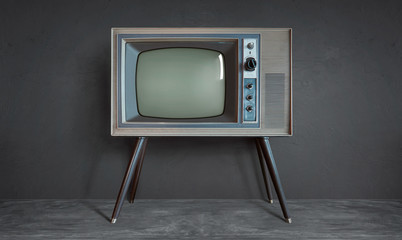 Vintage retro television on a cement wall background .