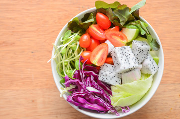 Top view of dish of Salad on wooden background.