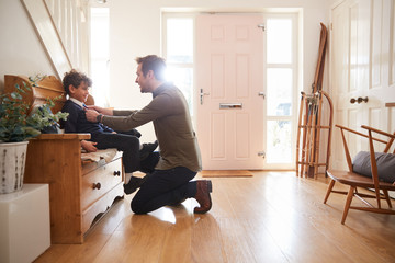 Single Father At Home Getting Son Wearing Uniform Ready For First Day Of School