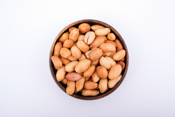 Roasted peanuts are in bowl, top view photo of peanut