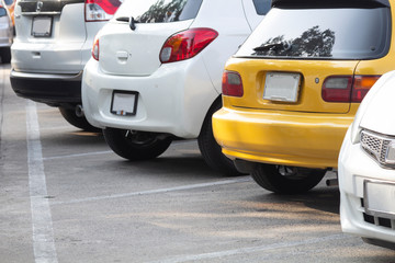 Yellow and white car parked inside outdoor parking in line.