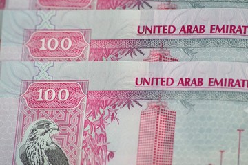 Close-up of 100 dirhams banknotes, the official currency of the United Arab Emirates. Banking background.