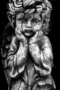 Old and Cracked Statue of Cherub Little child