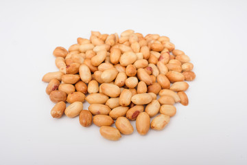 Heap of roasted peanuts, peanuts are on the isolated white surface