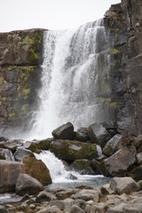 beautiful iceland waterfall with rocks and skies
