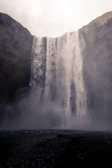 beautiful iceland waterfall with rocks and skies