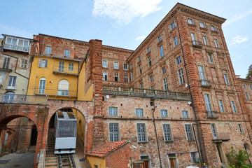MONDOVI, ITALY - AUGUST 18, 2016: Funicular train and ancient bricks buildings in a sunny summer day in Mondovi, Italy.