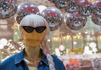 Wooden women's mannequin in a jeans jacket and sunglasses.