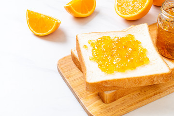 Fototapeta na wymiar Slices of bread with orange jam