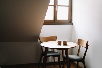 Two cups on wooden table. Dining room with table and two chairs. Modern minimal Scandinavian nordic interior. Morning coffee