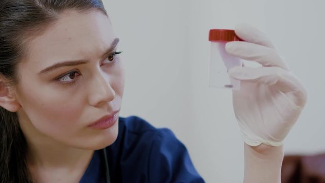 Woman surgeon examing removed tick