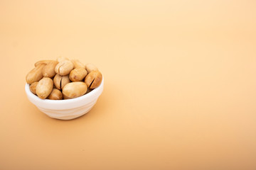 Peanuts in white porchelain, peanuts on the isolated yellow background
