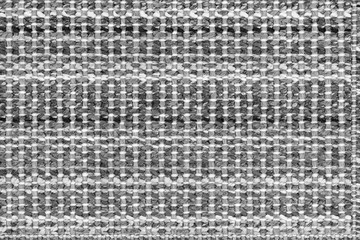 White and black knitted fabric background texture. gray fabric with a pattern. Fragment grey wool carpet, bright wicker dark rug