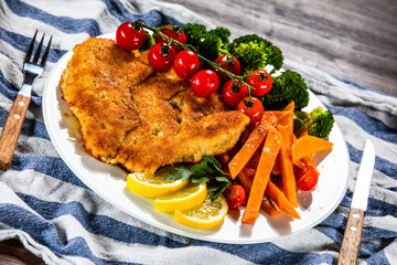 Fried pork chop, French fries and vegetable salad