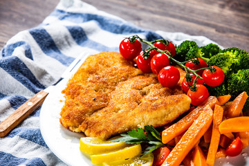 Fried pork chop, French fries and vegetable salad