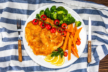 Fried pork chop, French fries and vegetable salad